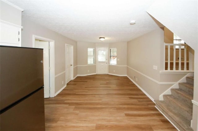 interior space featuring a textured ceiling and light hardwood / wood-style floors