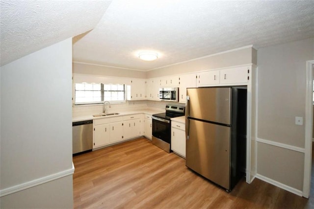 kitchen with light hardwood / wood-style flooring, stainless steel appliances, white cabinetry, and sink