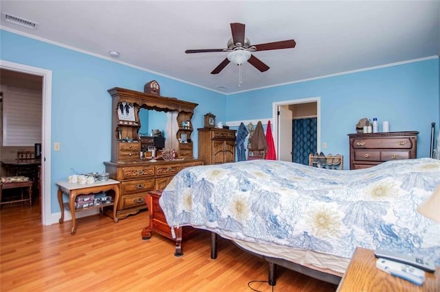 bedroom featuring ceiling fan, ornamental molding, and light wood-type flooring