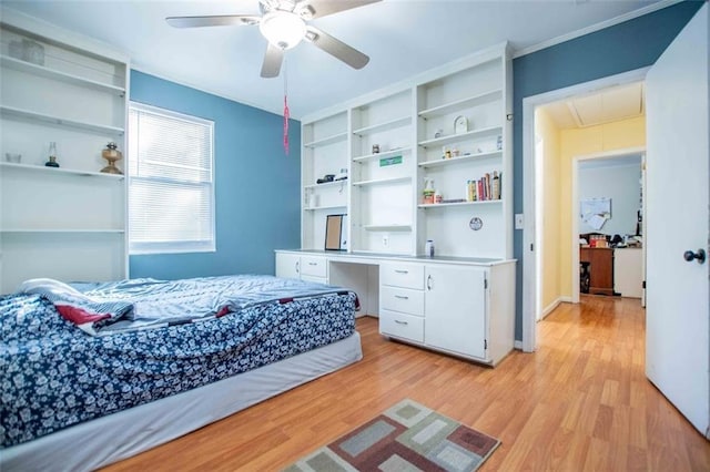 bedroom featuring built in desk, light hardwood / wood-style floors, and ceiling fan