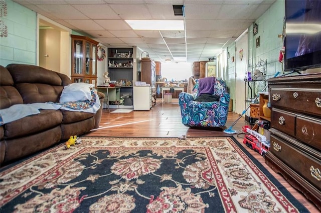 living room featuring a drop ceiling and light hardwood / wood-style flooring