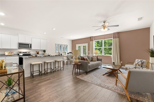 living room with ceiling fan and wood-type flooring