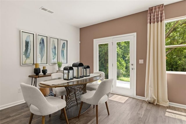 dining area with a wealth of natural light and wood-type flooring