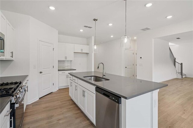 7252 Eton Ln, Locust Grove, GA 30248 - kitchen with stainless steel appliances, dark countertops, light wood-style floors, white cabinets, and recessed lighting