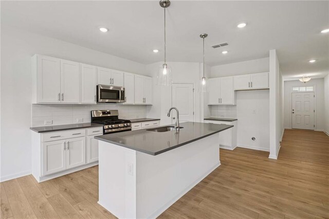 7252 Eton Ln, Locust Grove, GA 30248 - kitchen with a center island with sink, tasteful backsplash, dark countertops, and white cabinets
