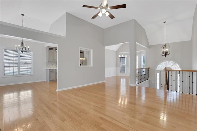 207 Amaranth Ct, Ball Ground, GA 30107 - unfurnished living room featuring a chandelier, high vaulted ceiling, a ceiling fan, light wood-style flooring, and healthy amount of natural light