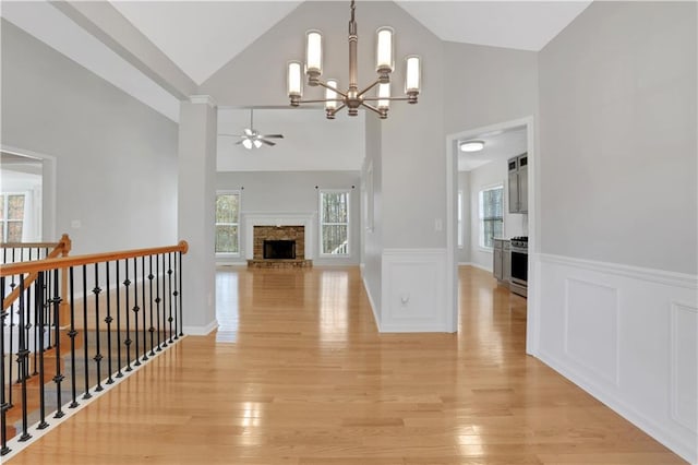 207 Amaranth Ct, Ball Ground, GA 30107 - hallway featuring a chandelier, healthy amount of natural light, light wood finished floors, a wainscoted wall, and high vaulted ceiling
