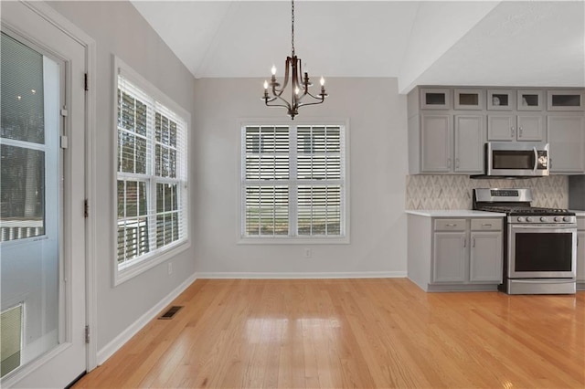 207 Amaranth Ct, Ball Ground, GA 30107 - kitchen featuring stainless steel appliances, gray cabinets, a chandelier, light wood-type flooring, and lofted ceiling