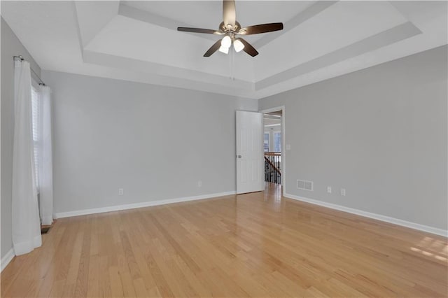 207 Amaranth Ct, Ball Ground, GA 30107 - spare room featuring a tray ceiling, light wood-style flooring, and a ceiling fan