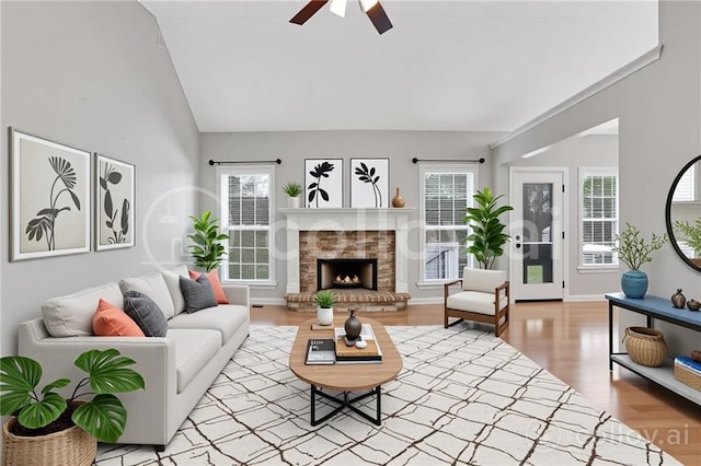 207 Amaranth Ct, Ball Ground, GA 30107 - living area with ceiling fan, healthy amount of natural light, light wood-style flooring, a lit fireplace, and high vaulted ceiling