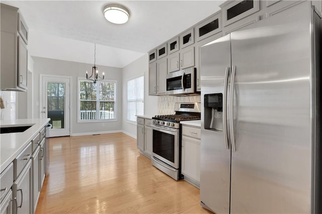 207 Amaranth Ct, Ball Ground, GA 30107 - kitchen with stainless steel appliances, light countertops, a chandelier, and light wood finished floors