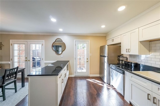 kitchen with french doors, dark hardwood / wood-style floors, ornamental molding, appliances with stainless steel finishes, and white cabinetry