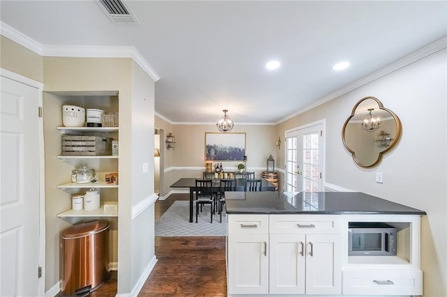 kitchen with white cabinetry, french doors, dark wood-type flooring, a chandelier, and ornamental molding