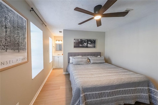 bedroom featuring connected bathroom, ceiling fan, and light hardwood / wood-style flooring