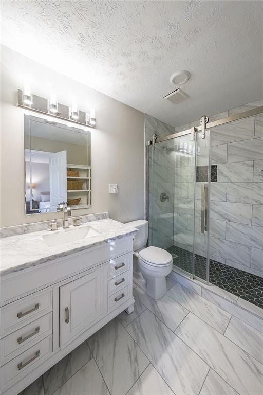 bathroom with vanity, a textured ceiling, toilet, and a shower with shower door