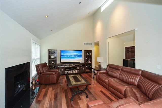 living room with hardwood / wood-style floors and high vaulted ceiling