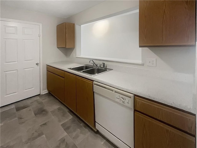 kitchen with a sink, light countertops, white dishwasher, and brown cabinetry