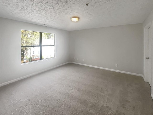 carpeted spare room with baseboards and a textured ceiling