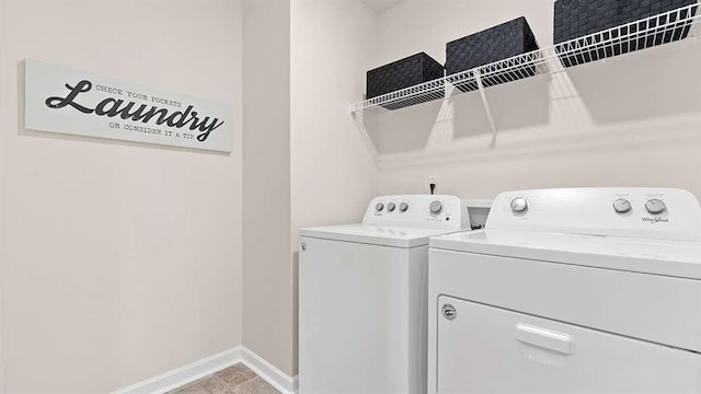 clothes washing area with light tile patterned floors and washer and clothes dryer