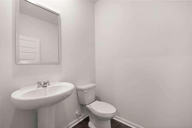 bathroom featuring hardwood / wood-style flooring and toilet