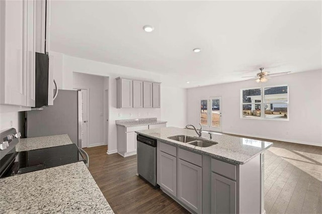 kitchen with dark hardwood / wood-style flooring, a center island with sink, sink, and appliances with stainless steel finishes