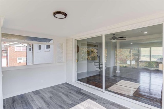 unfurnished sunroom with ceiling fan