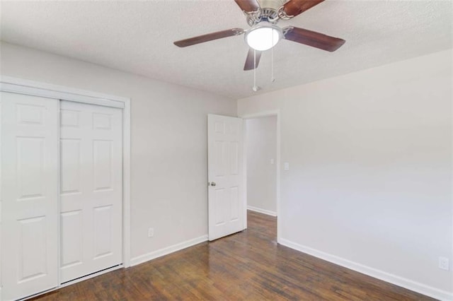 unfurnished bedroom with a textured ceiling, a closet, ceiling fan, and dark wood-type flooring