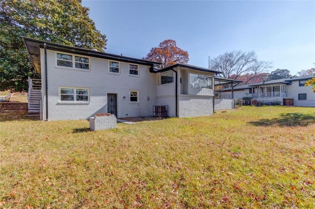 back of property featuring a sunroom and a yard