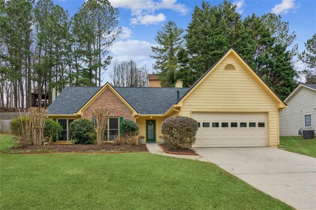 ranch-style home featuring a garage and a front yard