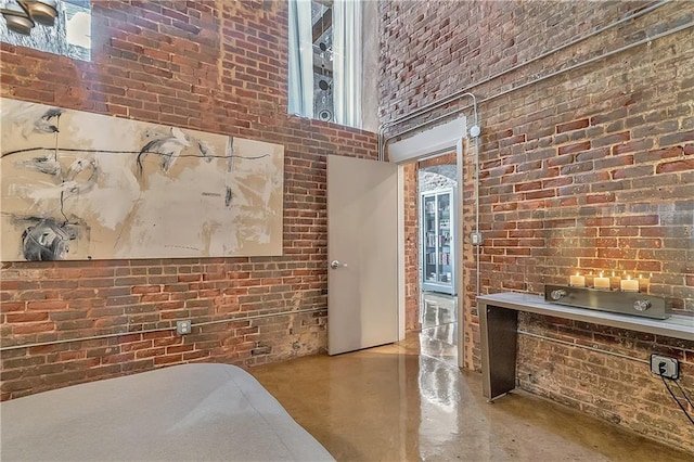 interior space featuring brick wall and a towering ceiling