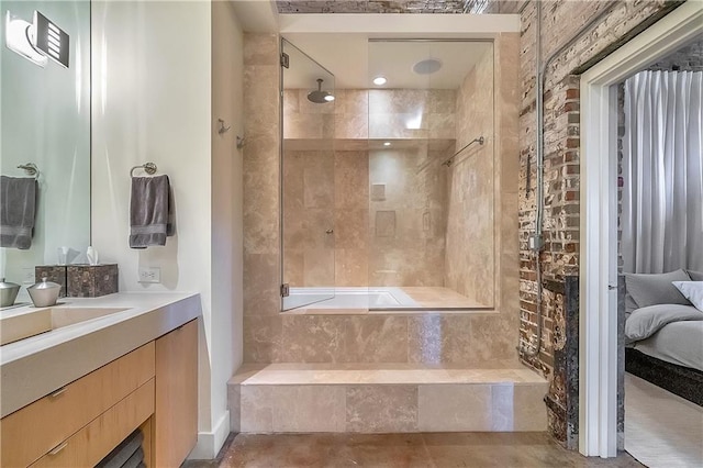 bathroom featuring vanity and a relaxing tiled bath