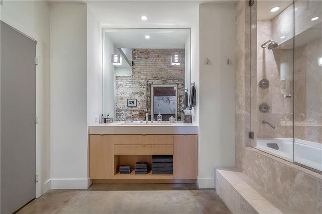 bathroom with concrete floors, dual sinks, large vanity, and tiled shower / bath