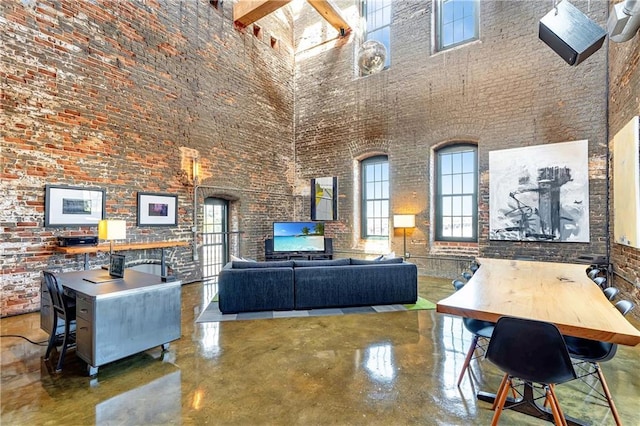 dining space featuring a high ceiling and brick wall