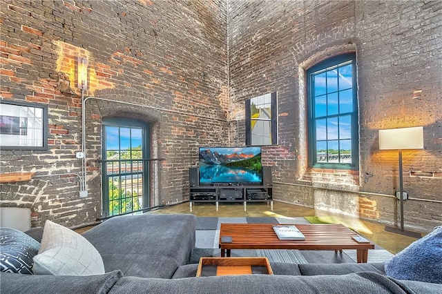 living room featuring brick wall and a towering ceiling