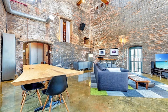 dining area with brick wall and a high ceiling