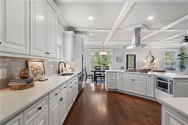 kitchen featuring stainless steel appliances, a wealth of natural light, coffered ceiling, and a sink