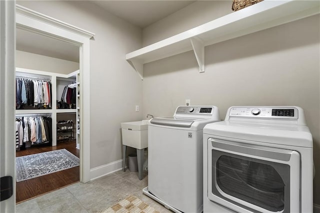 laundry room featuring light tile patterned floors, baseboards, laundry area, and washer and clothes dryer