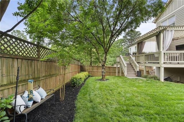 view of yard with a deck, stairway, and a fenced backyard