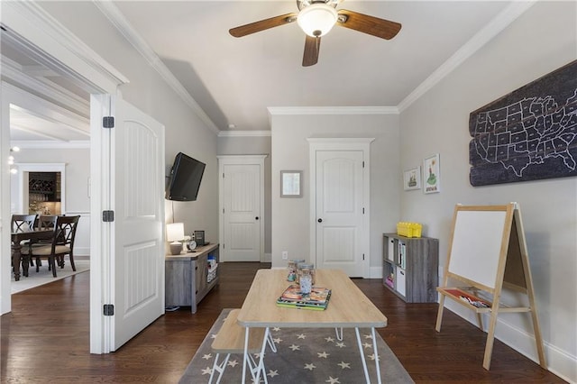 rec room featuring ornamental molding, a ceiling fan, and dark wood finished floors