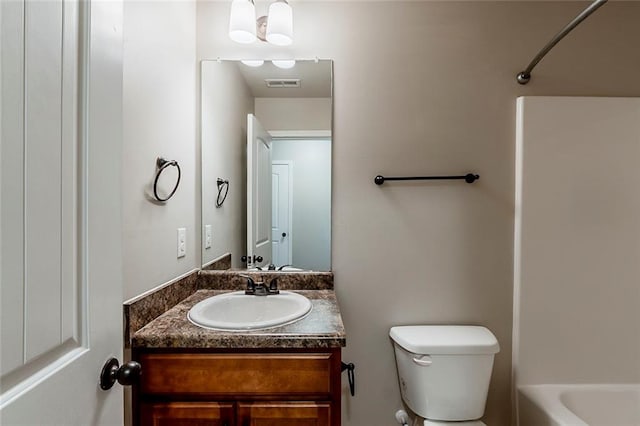 bathroom with toilet, vanity, and  shower combination