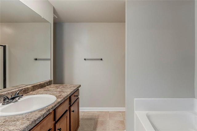 full bathroom featuring a bath, baseboards, and vanity