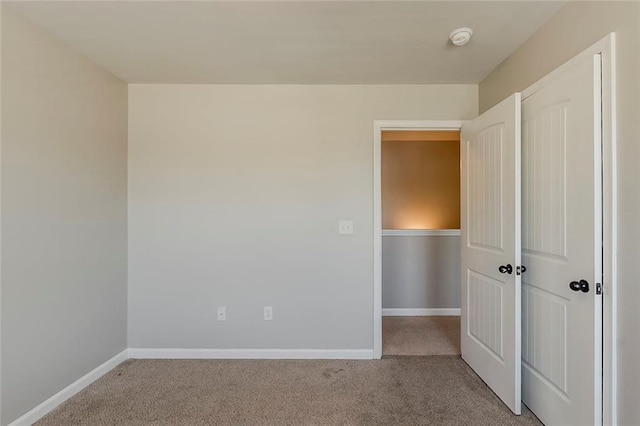 unfurnished bedroom featuring carpet flooring and baseboards