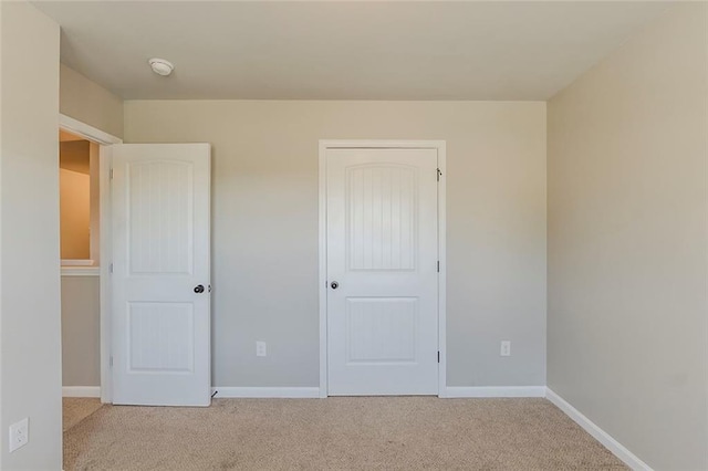 unfurnished bedroom with carpet floors and baseboards