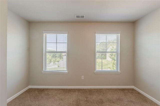 carpeted empty room featuring baseboards