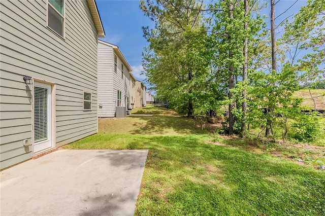 view of grassy yard featuring a patio and central AC