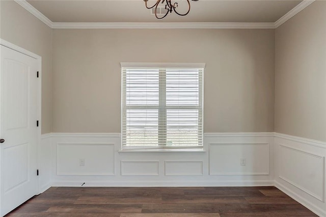 unfurnished dining area with a chandelier, a wainscoted wall, crown molding, and dark wood-style flooring