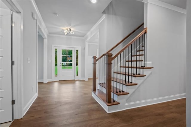 foyer with ornamental molding and dark hardwood / wood-style floors