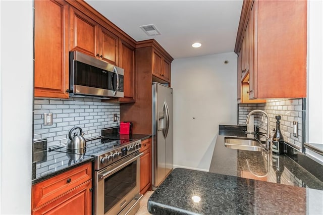 kitchen featuring tasteful backsplash, visible vents, dark stone counters, appliances with stainless steel finishes, and a sink