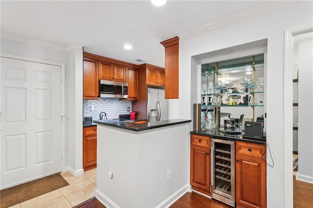 kitchen with dark countertops, tasteful backsplash, wine cooler, appliances with stainless steel finishes, and crown molding