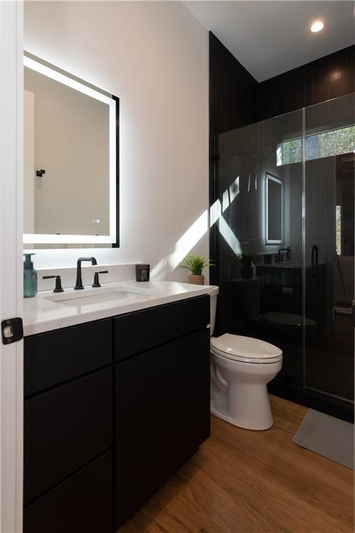 269 Clarice Ln, Sautee Nacoochee, GA 30571 - bathroom featuring a stall shower, wood finished floors, vanity, and toilet